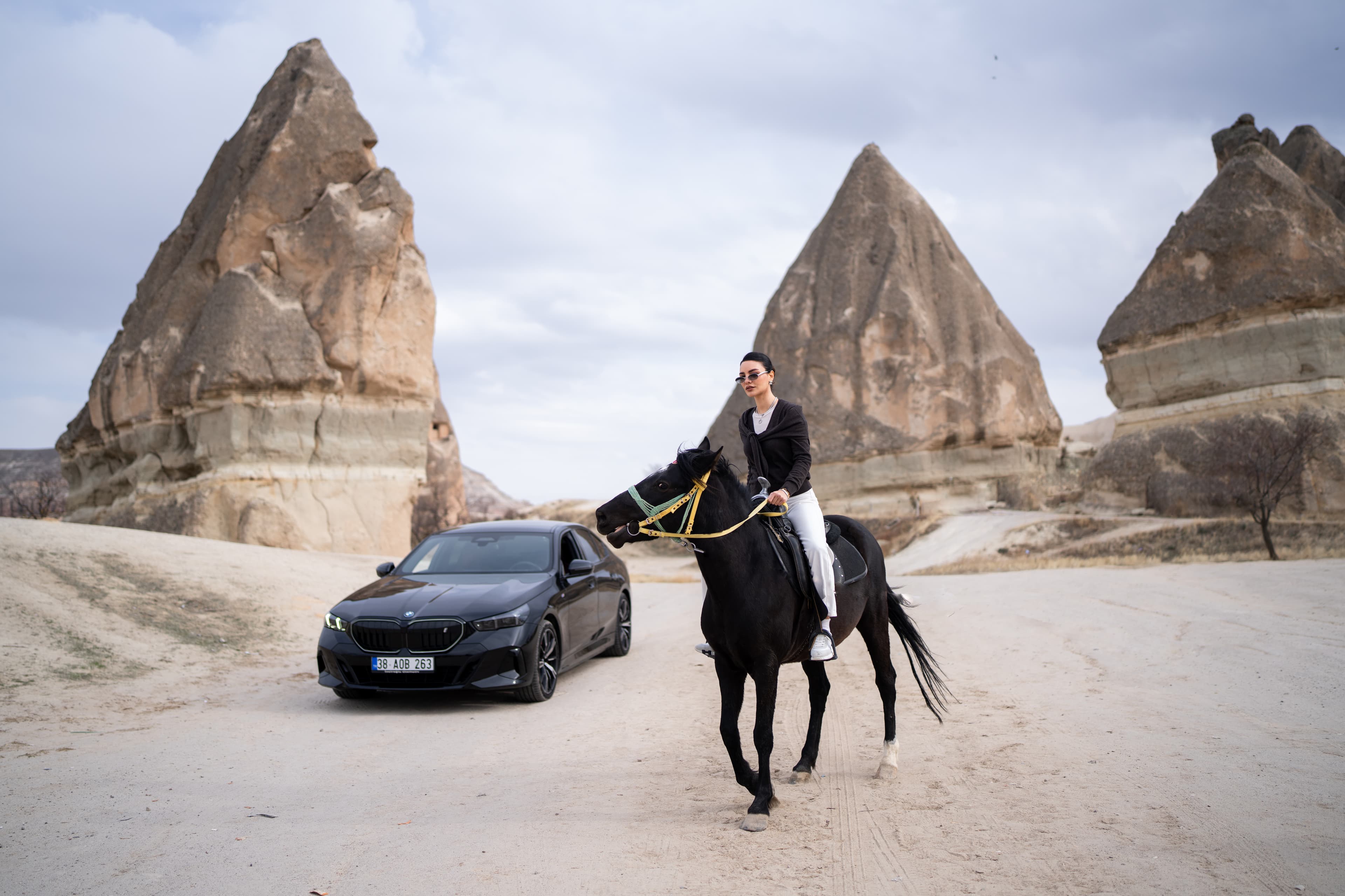 Woman on horseback beside a car in Cappadocia